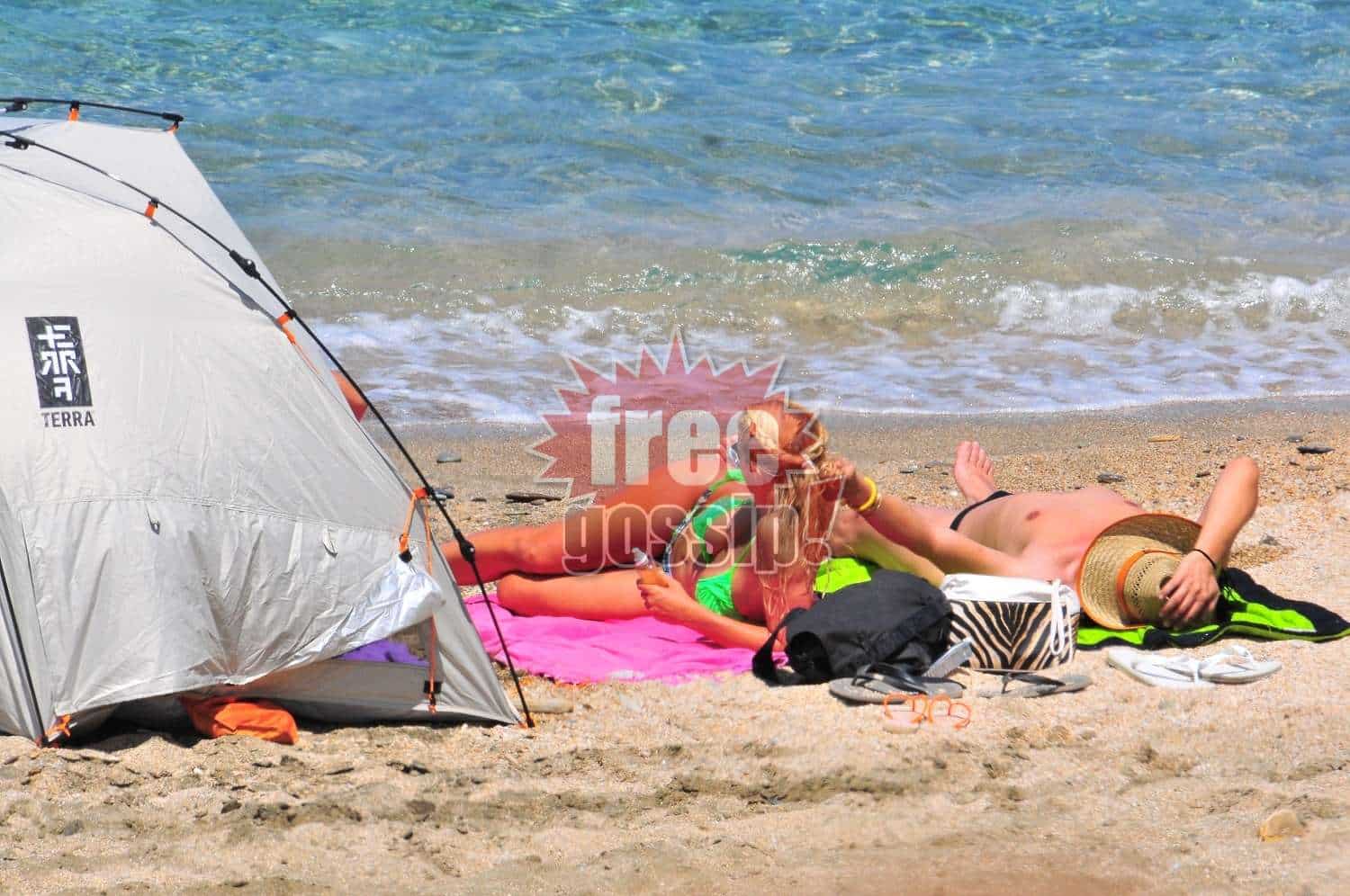 Ελένη Μενεγάκη hair salon on the beach! Ο κομμωτής δίπλα της πλέκει κοτσίδες ξαπλωμένος!